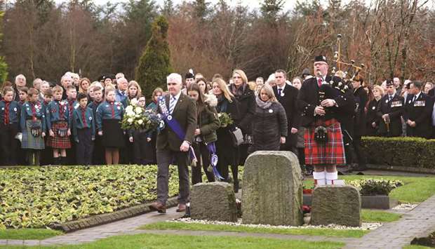 A piper plays as people attend a service to mark the 30th anniversary of the Lockerbie air disaster, at the Memorial Garden, Dryfesdale Cemetery, Lockerbie, southwestern Scotland, yesterday.