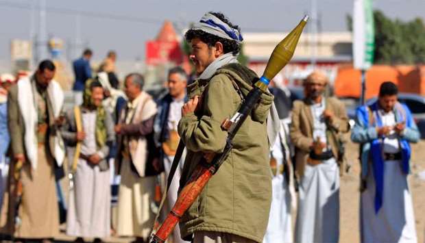 An armed Yemeni man holds a rocket launcher as people gather in the capital Sanaa