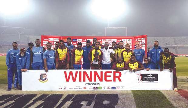 West Indies players pose with the trophy following their victory in the third Twenty20 match against Bangladesh at Sher-e-Bangla National Cricket Stadium in Dhaka yesterday. (AFP)