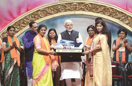 Prime Minister Narendra Modi stands with dignitaries on stage during the Bharatiya Janata Party (BJP) Mahila Morcha sammelan in Adalaj, some 30km from Ahmedabad yesterday.