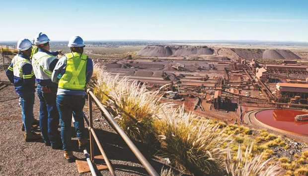 Visitors look out towards the iron ore processing plant at the Sishen open cast mine, operated by Kumba Iron Ore Ltd, a unit of Anglo American, in Sishen, South Africa. Anglo American, the company that grew to be South Africau2019s biggest during apartheid, says itu2019s ready to invest in the country again.