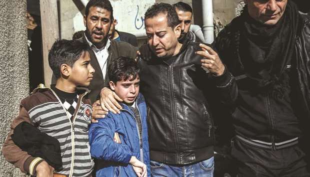 The father (second right) of 16-year-old Palestinian Mohamed al-Jahjuh embraces the teenageru2019s brother (second left) during his funeral in Gaza City, yesterday.