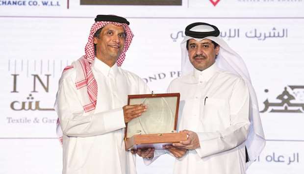 Ahmad Ali al-Hanzab, head of Administration and Property Department at Doha Bank, receiving the appreciation shield on behalf of Doha Bank.
