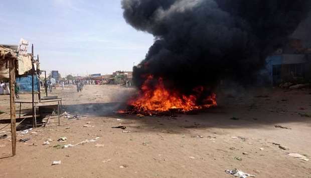 A bonfire is lit along the street during protests against price increases in Atbara, Nile River state in northeastern Sudan on December 20, 2018