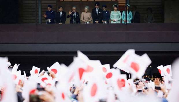 Japan's Emperor Akihito, flanked by Empress Michiko, Crown Prince Naruhito, Crown Princess Masako and other royal members wave to well-wishers who gathered to celebrate the emperor's 85th birthday at the Imperial Palace in Tokyo