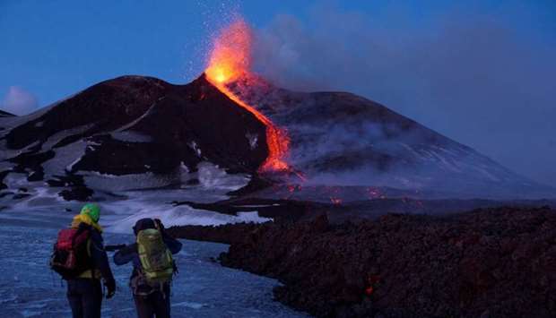 Volcano guides stand in front of Italy's Mount Etna, Europe's tallest and most active volcano, as it spews lava during an eruption on the southern island of Sicily, Italy. File picture: February 28, 2017