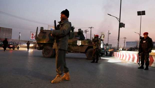 Afghan security forces stand guard at the site of an attack in Kabul, Afghanistan