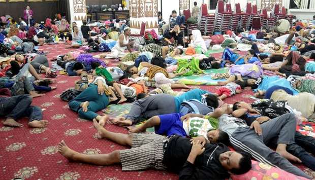 Residents, who lived at coast of Bandar Lampung, rest at government building after they evacuated following a tsunami hit Sunda strait in Lampung