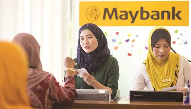 An employee serves a customer at the information counter inside a combined Malayan Banking Bhd (Maybank) and Maybank Islamic Bhd bank branch in Kuala Lumpur (file). The fast growing global Islamic economy, estimated currently at $6.4tn, has become a main driver for Islamic finance institutions and other sector players to intensify their globalisation efforts.