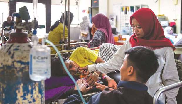 Family members visit a tsunami survivor at a hospital ward in Kalianda, Lampung province yesterday.