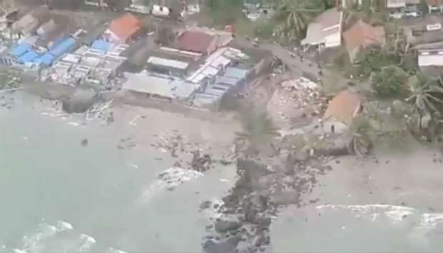 Debris surround buildings along a shore after a tsunami hit Kalianda, Lampung province, Indonesia