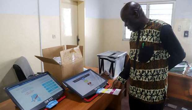 A worker of Congo's National Independent Electoral Commission (CENI), tests a voting machine ahead of the postponed presidential election, at the CENI offices in Kinshasa