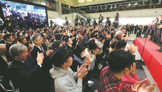 People clap during a ceremony to celebrate the end-of-year trading at the Tokyo Stock Exchange. The benchmark Nikkei index closed lower yesterday, ending the year with its first annual loss since 2011, as negative factors including US-China trade tensions weighed on the market.