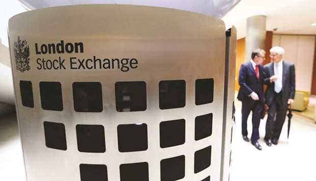 Visitors pass a sign inside the main atrium of the London Stock Exchange. The FTSE 100 closed up 2.3% to 6,733.97 points yesterday.