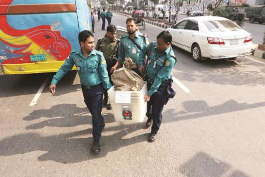 Law enforcement officials are seen carrying voting materials including ballot boxes ahead of 11th general election which will be held today, in Dhaka yesterday.