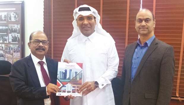 Jumbo Electronics vice-chairman and managing director Sajed Jassim Mohamed Sulaiman hands over the 2019 Business Strategy document to director and CEO C V Rappai as COO Rohit Pandit looks on.