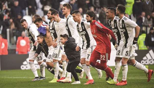 Two young fans celebrate with Juventusu2019 Portuguese forward Cristiano Ronaldo (fourth right) and his teammates after the defending champions win over Sampdoria in the Italian Serie A at the Juventus stadium in Turin on Saturday night. (AFP)