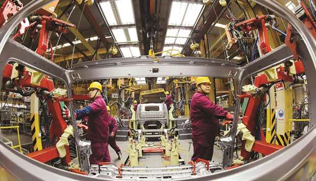 Employees work on a production line manufacturing light trucks at a JAC Motors plant in Weifang, Shandong province. The official Purchasing Managersu2019 Index u2013 the first snapshot of Chinau2019s economy each month u2013 fell to 49.4 in December, below the 50-point level that separates growth from contraction, a National Bureau of Statistics survey showed yesterday.