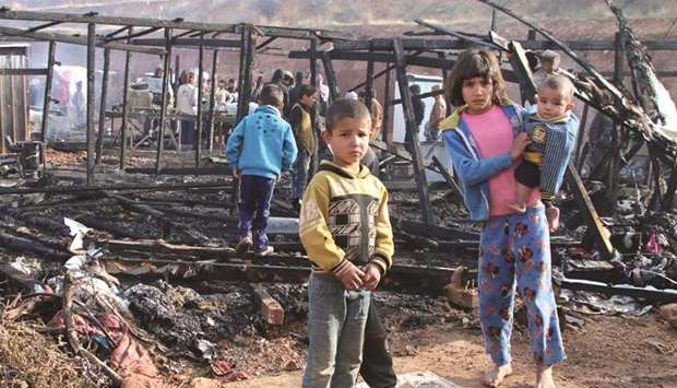 Syrian refugees check the damage following a fire that ripped through their refugee camp in the village of Yammouneh in Lebanonu2019s eastern Bekaa Valley, yesterday.
