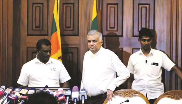 Sri Lankau2019s ousted PM Ranil Wickremesinghe, centre, arrives at a news conference after a court issued an order preventing newly appointed prime minister Mahinda Rajapakse from acting as prime minister and holding cabinet meetings in Colombo, yesterday.