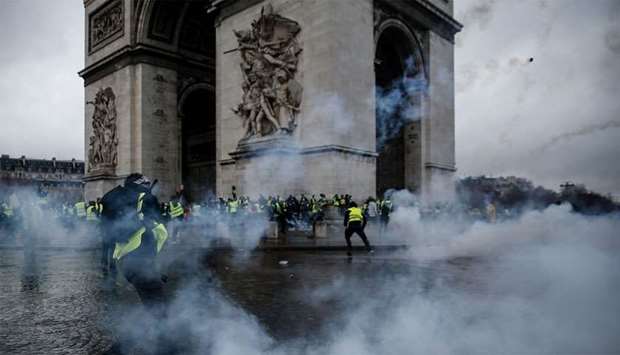 Demonstrators clash with riot police at the Arc de Triomphe during a protest of Yellow vests (Gilets jaunes) against rising oil prices and living costs