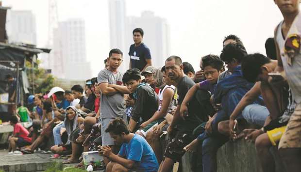 A crowd of Filipino workers are seen waiting for short term employment outside a seaport in Manila, yesterday.