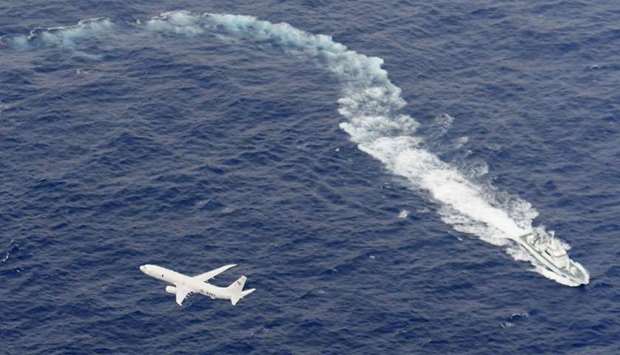A Japan Coast Guard patrol vessel and US Navy airplane conduct search and rescue operation at the ar