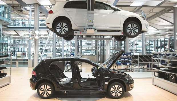 A Volkswagen e-Golf electric automobile moves along the assembly line inside the VW factory in Dresden, Germany. Still battling to recover from a 2015 scandal over emissions test cheating, the automaker has been cutting costs to fund an ambitious shift to electric cars and automated driving.