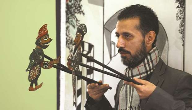 Shadi al-Hallaq, a puppeteer, holds two puppets during a performance in Damascus.