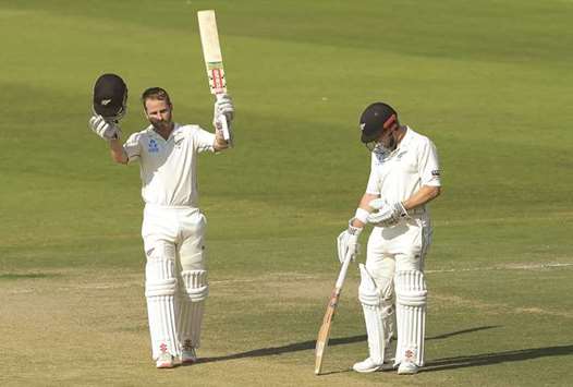 New Zealand captain Kane Williamson (L) acknowledges the applause after notching a century as teammate Henry Nicholls looks on in Abu Dhabi yesterday.