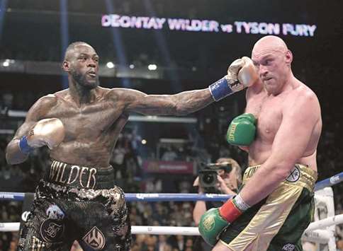 Deontay Wilder (left) punches Tyson Fury during their drawn bout for the WBC  Heavyweight Championship in Los Angeles, California on Saturday. (AFP)