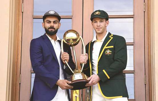 India captain Virat Kohli (L) and Australian skipper Tim Paine pose with the Border-Gavaskar trophy at the Adelaide Oval yesterday.  The first Test match between the two teams begins today. EPA photo