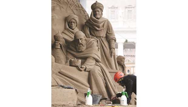 A sand sculptor works on a nativity scene at Saint Peteru2019s Square in the Vatican.
