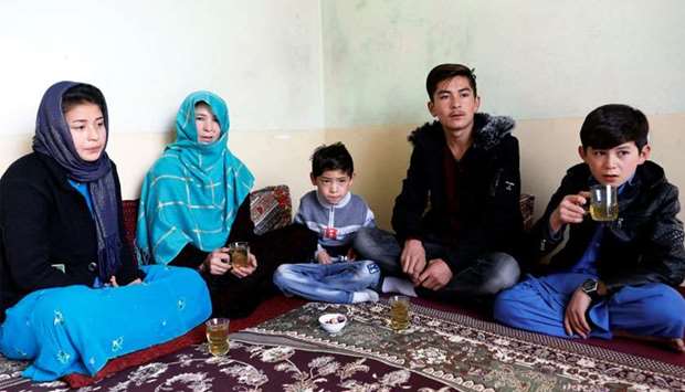 Murtaza Ahmadi, 7, (C) an Afghan Lionel Messi fan, sits with his family at their house in Kabul