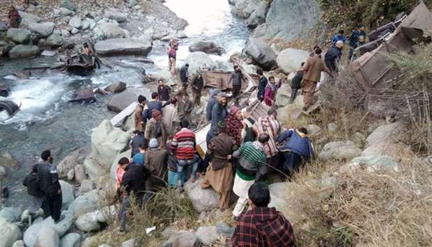 People gather at the accident scene where a bus fell into a gorge in the mountains of Poonch, some 200 kilometres south of Srinagar