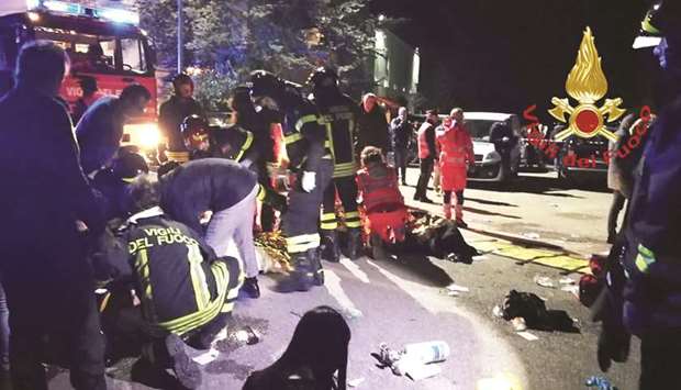 This handout picture taken and released by Vigili del Fuoco, the Italian fire and rescue service, yesterday shows emergency personnel treating victims after the stampede at a nightclub in Cornaldo.