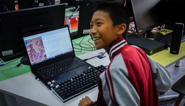 A boy laughing while running a code at a children's computer coding training centre in Beijing