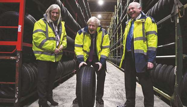 Prime Minister and Conservative leader Boris Johnson looks at tyres in a warehouse with CEO Alan Ferguson (right) and Conservative parliamentary candidate for Washington and Sunderland West Valerie Allen during a general election campaign visit to Fergusons Transport in the town of Washington, west of Sunderland, northeast England, yesterday.