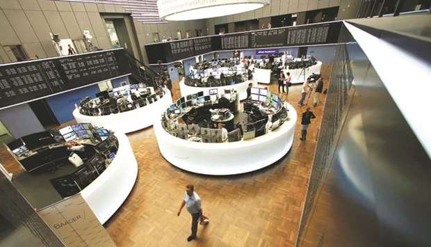 Traders work in front of the DAX board at the Frankfurt Stock Exchange. The DAX 30 closed 0.3% lower at 13,070.72 points yesterday.