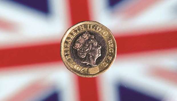 A British one pound sterling coin is arranged for a photograph in front of a Union flag in London. Investors have ramped up their bets in recent days that the governing Conservative  Party would win a majority in the election tomorrow, although political pundits are far more cautious.