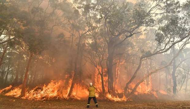 A firefighter conducting back-burning measures to secure residential areas from encroaching bushfire