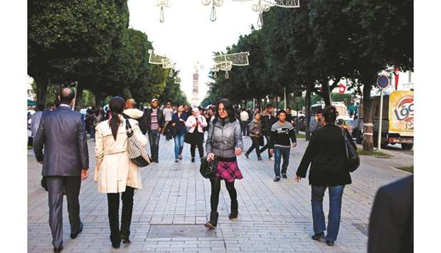 Pedestrians walk along Avenue Bourguiba in Tunis (file). Tunisiau2019s parliament backed an ambitious budget that aims to double economic growth next year and narrow the deficit as a new leadership bids to address the aspirations of a  generation fed up with post-Arab Spring stagnation.