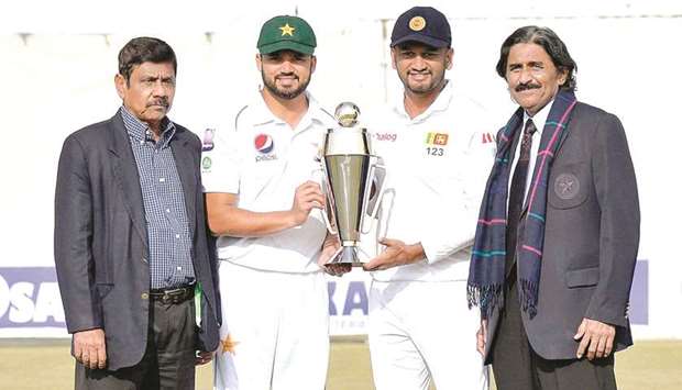 YESTERDAY ONCE MORE: Current Pakistan captain Azhar Ali and Sri Lankan skipper Dimuth Karunaratne holding the trophy with Bandula Warnapura, left, and Javed Miandad, right, before the start of the first Test in a decade which began at the Rawalpindi Cricket Stadium yesterday. Warnapura and Miandad led their respective sides in the first ever Test between the two countries in 1982.
