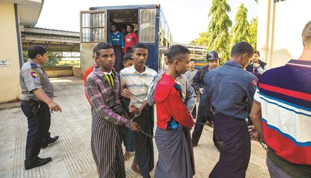 Rohingya detainees step out of a police van upon arriving at the court in the western Myanmar city of Pathein ahead of a hearing yesterday.