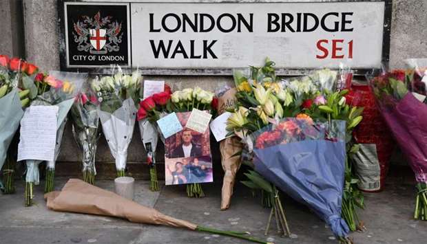Floral tributes and photographs of the first victim to be named, Jack Merritt, are pictured close to London Bridge in the City of London