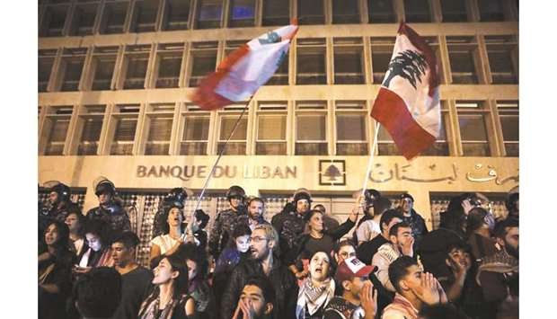 Lebanese anti-government protesters shout slogans outside the headquarters of Lebanonu2019s central bank in the capital Beirut on November 28. The World Bank projected negative growth of 0.2% in Lebanon for 2019, but now warns the recession could be even worse.