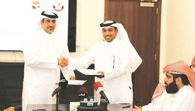 Executive Director of Qatar Olympic Academy Saif al-Nuaimi (left) and the Director of the Sports  Affairs Department at the Ministry Isa al-Harami pose after the agreement signing ceremony.