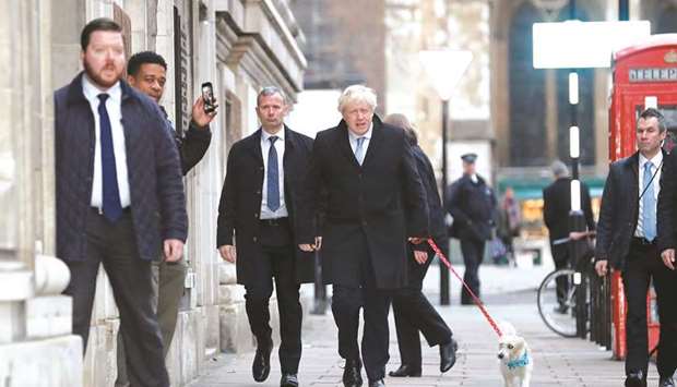 Prime Minister Boris Johnson arrives with his dog Dilyn at a polling station at the Methodist Central Hall to vote in the general election in London yesterday.