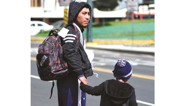 A migrant and his son deported from the US are seen outside the air force base upon their arrival in Guatemala City.