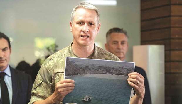 New Zealand Army Colonel Rian McKinstry holds a photo showing soldiers taking part in a mission to retrieve bodies from White Island.